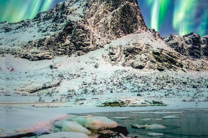 Aurora Borealis (Northern lights) explosion over mountains in glacier