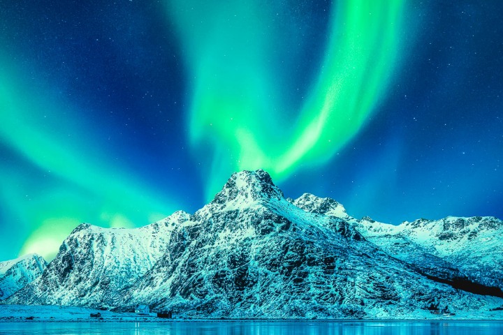 Aurora Borealis, Lofoten islands, Norway. Northen lights, mountains and reflection on the water. Winter landscape during polar lights. Norway travel - image